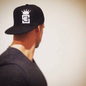 Black Snapback Cap with White embossed logo on athlete